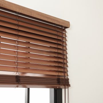 Modern window with stylish wooden blinds indoors. Space for text
